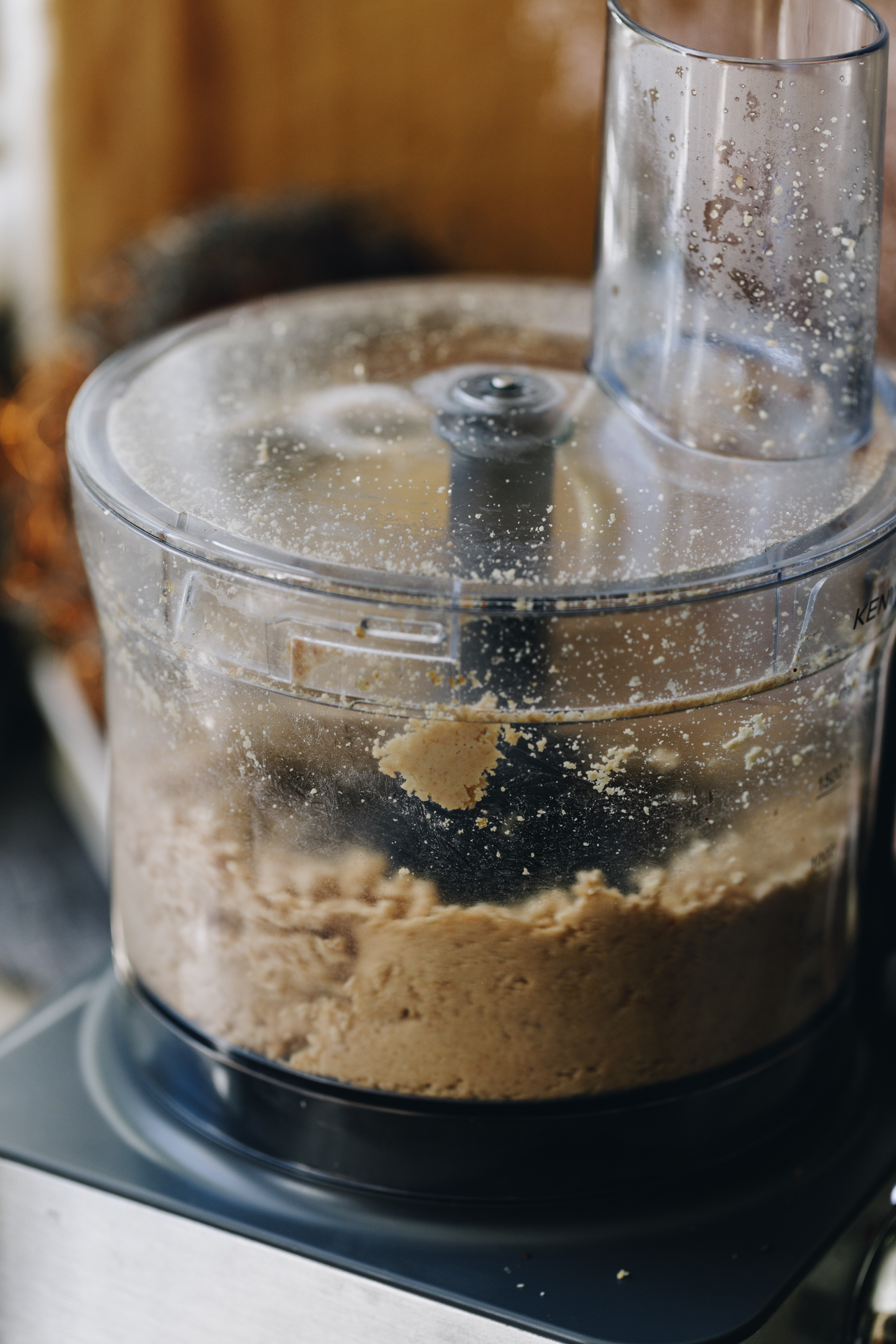 A food processor is blasting up almonds in to a puree. 