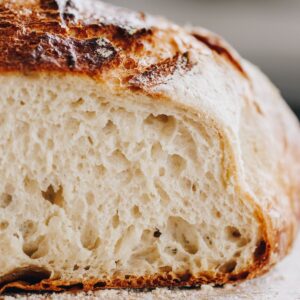 The open rustic bread loaf is cut open to reveal the bread texture.