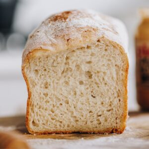 A loaf of no knead bread has been cut open to reveal the soft texture inside.