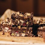 No-bake-hedgehog slice is cut in to slices and two pieces are stacked on top of each other, the texture of the slice and the chocolate topping can be side.