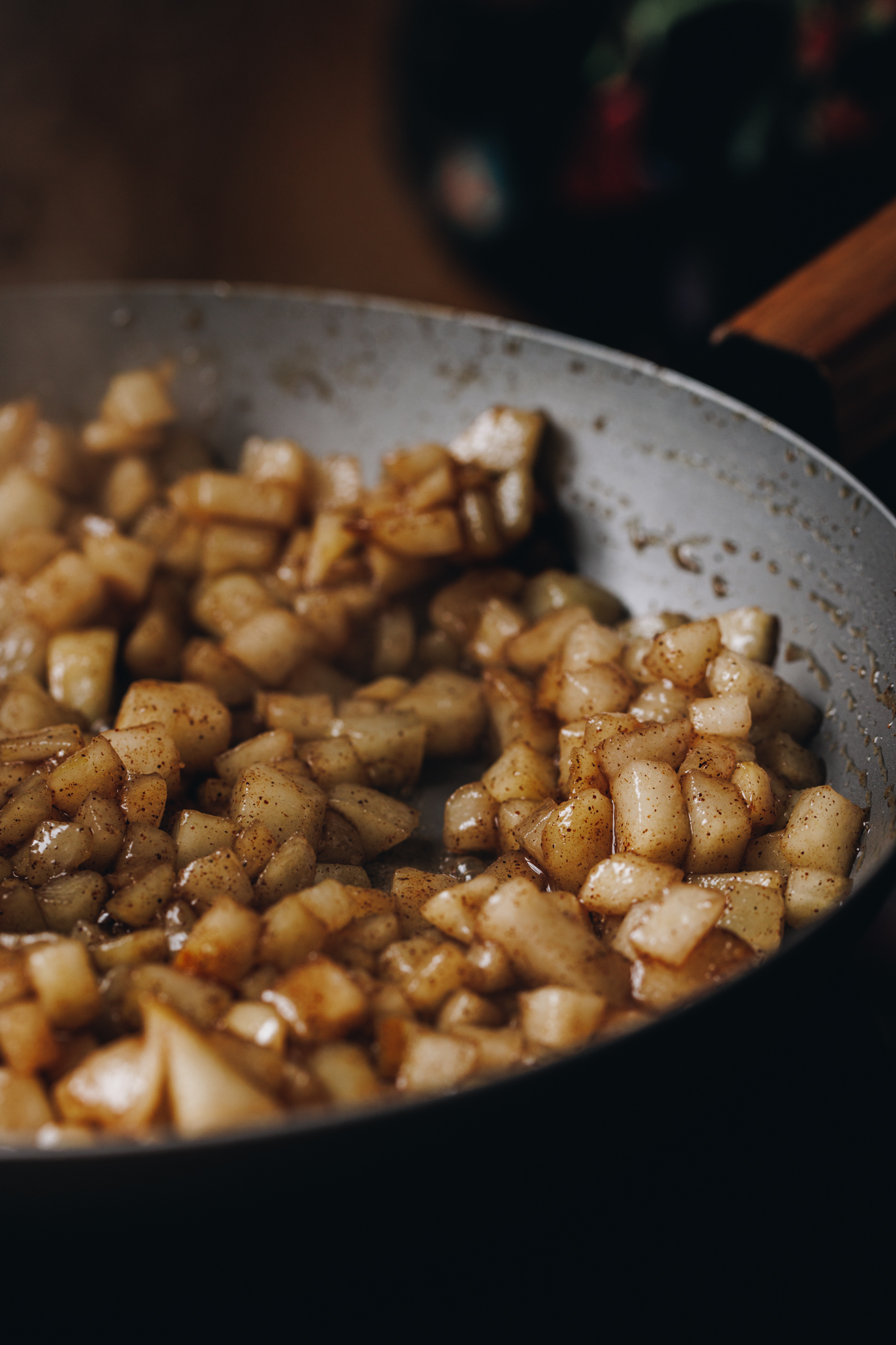 Easy spiced pear compote is cooking in a black cast iron pan.