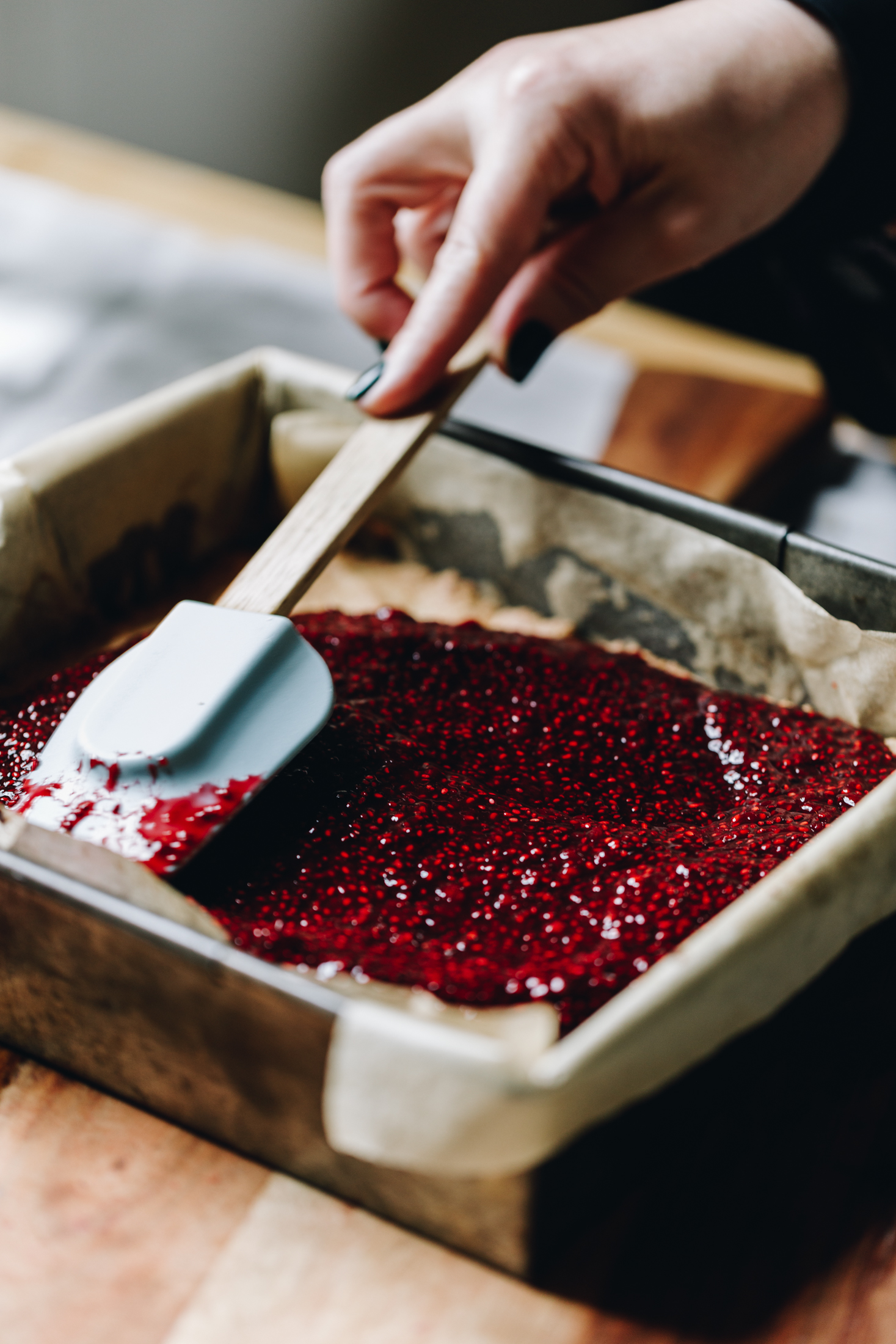 The jam is being spread over the hot Louise Cake Slice base. 