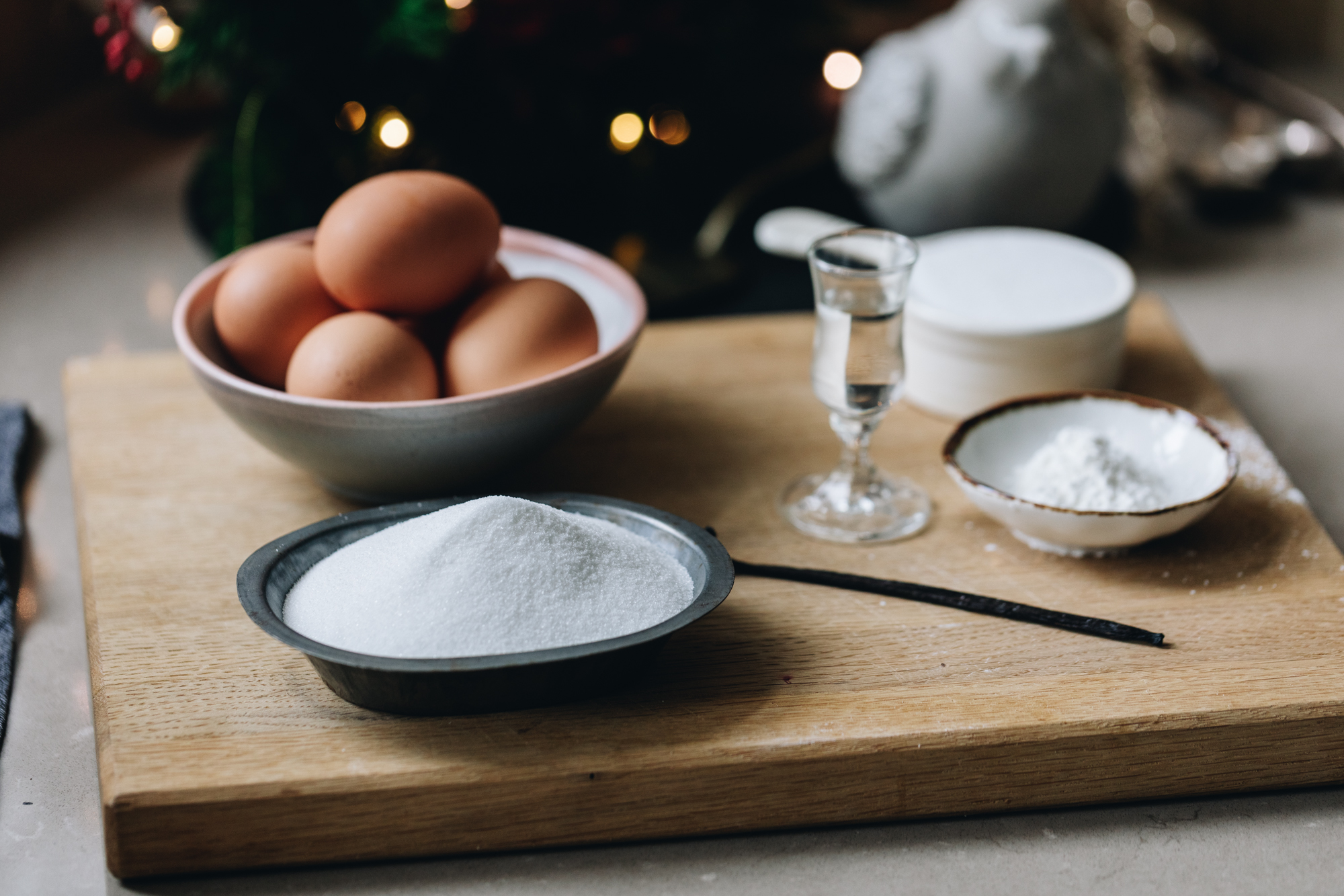 Swiss Meringue ingredients are in different vintage bowls and are sitting on a wooden board. 