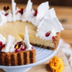 A key-lime pie is decorated with crispy meringue shards. They are rustic in shape and stick up in the air, off the pie.