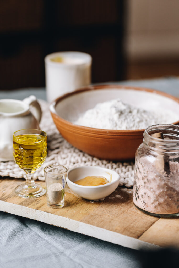 Ingredients are in different vintage bowls and are sitting on a wooden board on top of wooden table.