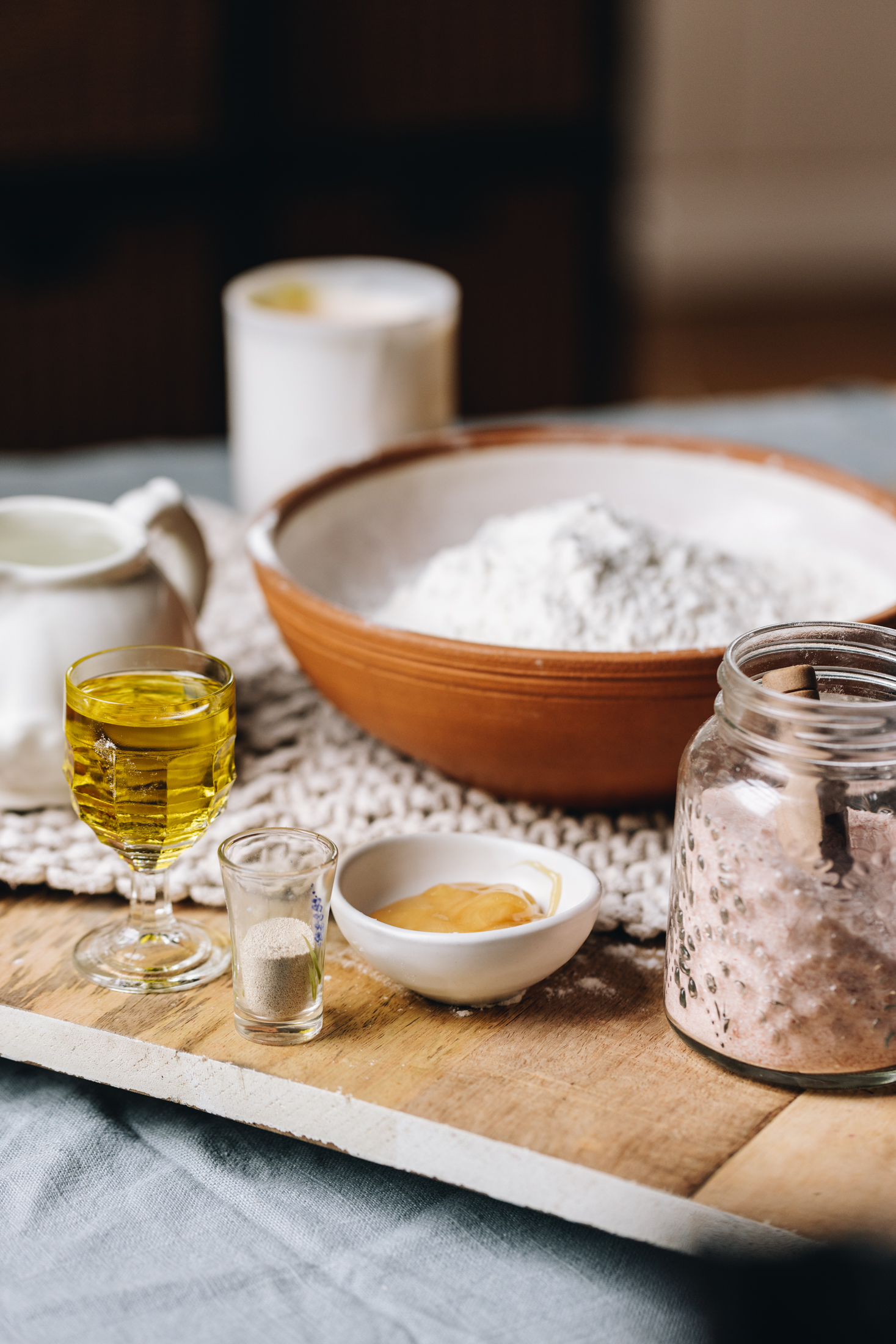 Ingredients are in different vintage bowls and are sitting on a wooden board on top of wooden table.