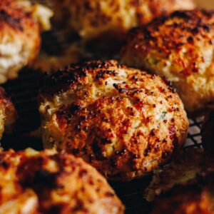 Close up shots of golden baked brie stuffed honey mustard scones with speckles of mustard seeds on top.
