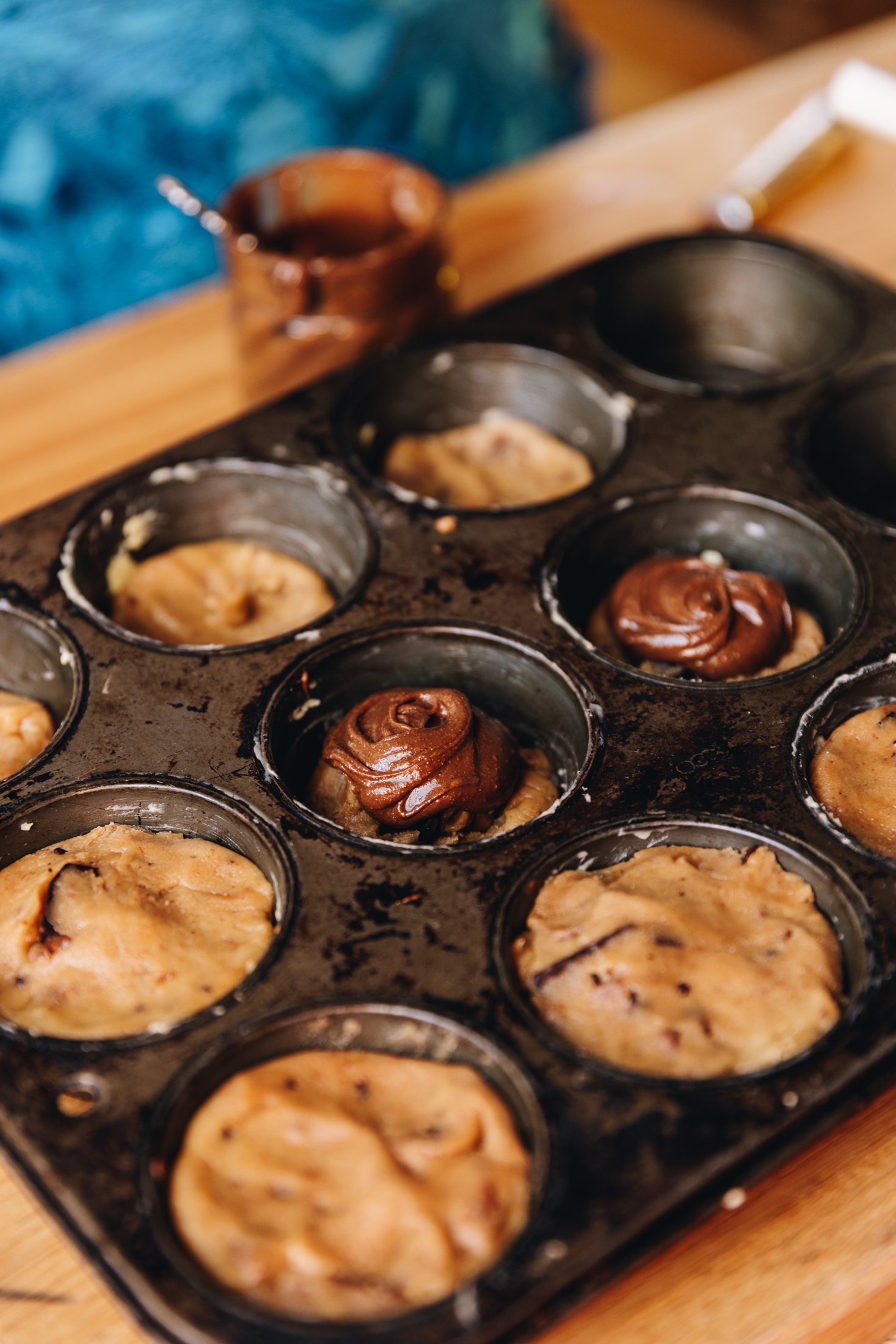 The cookie pie dough has been pressed in to a muffin tin. Some of the gooey pies have lids and a couple reveal the chocolate hazelnut centre.