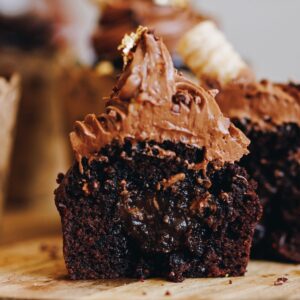 A gooey chocolate ganache muffin has been cut in half to show the gooey chocolate centre.
