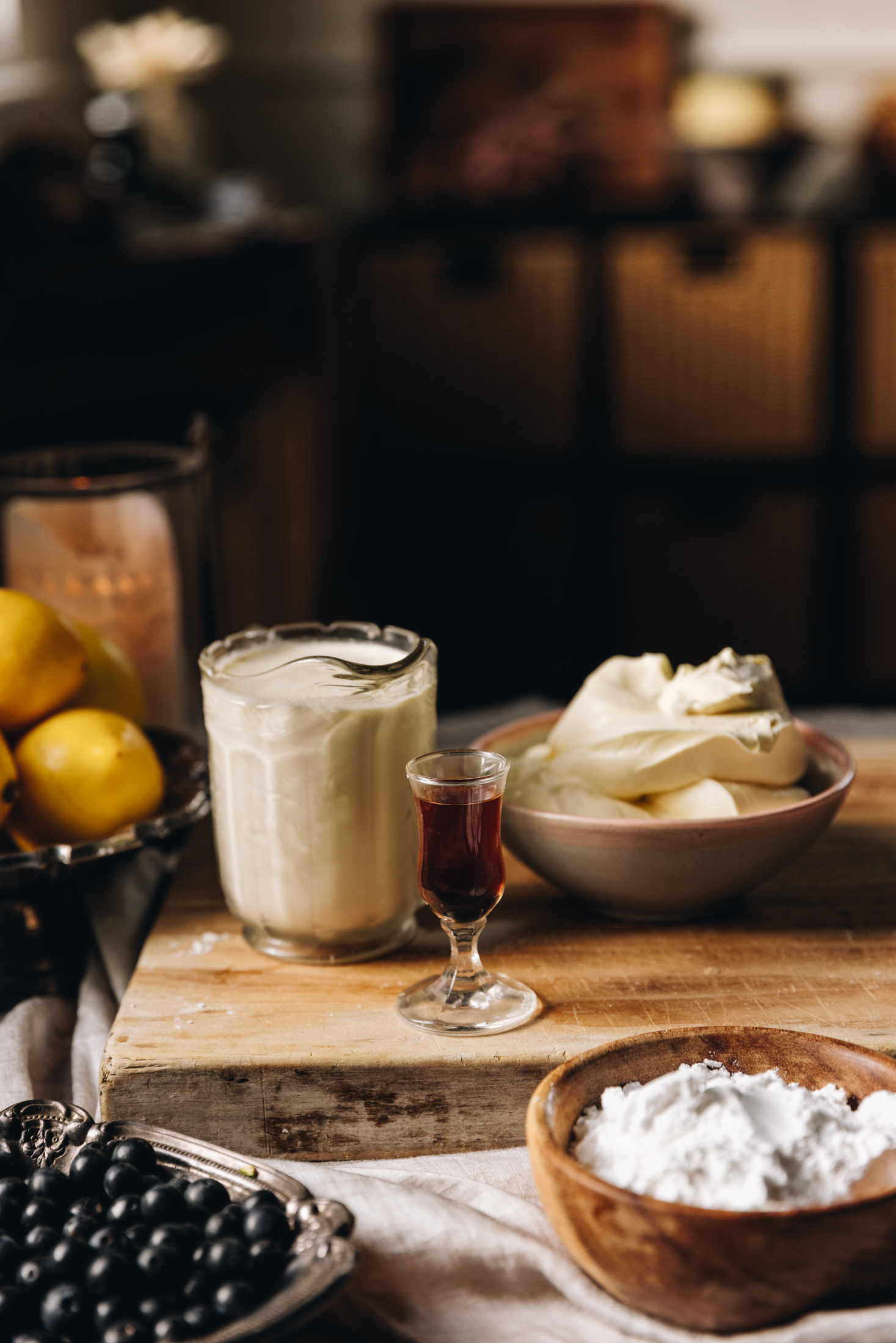 Stable whipped cream ingredients are in different vintage bowls and are sitting on a wooden board. ingredients.