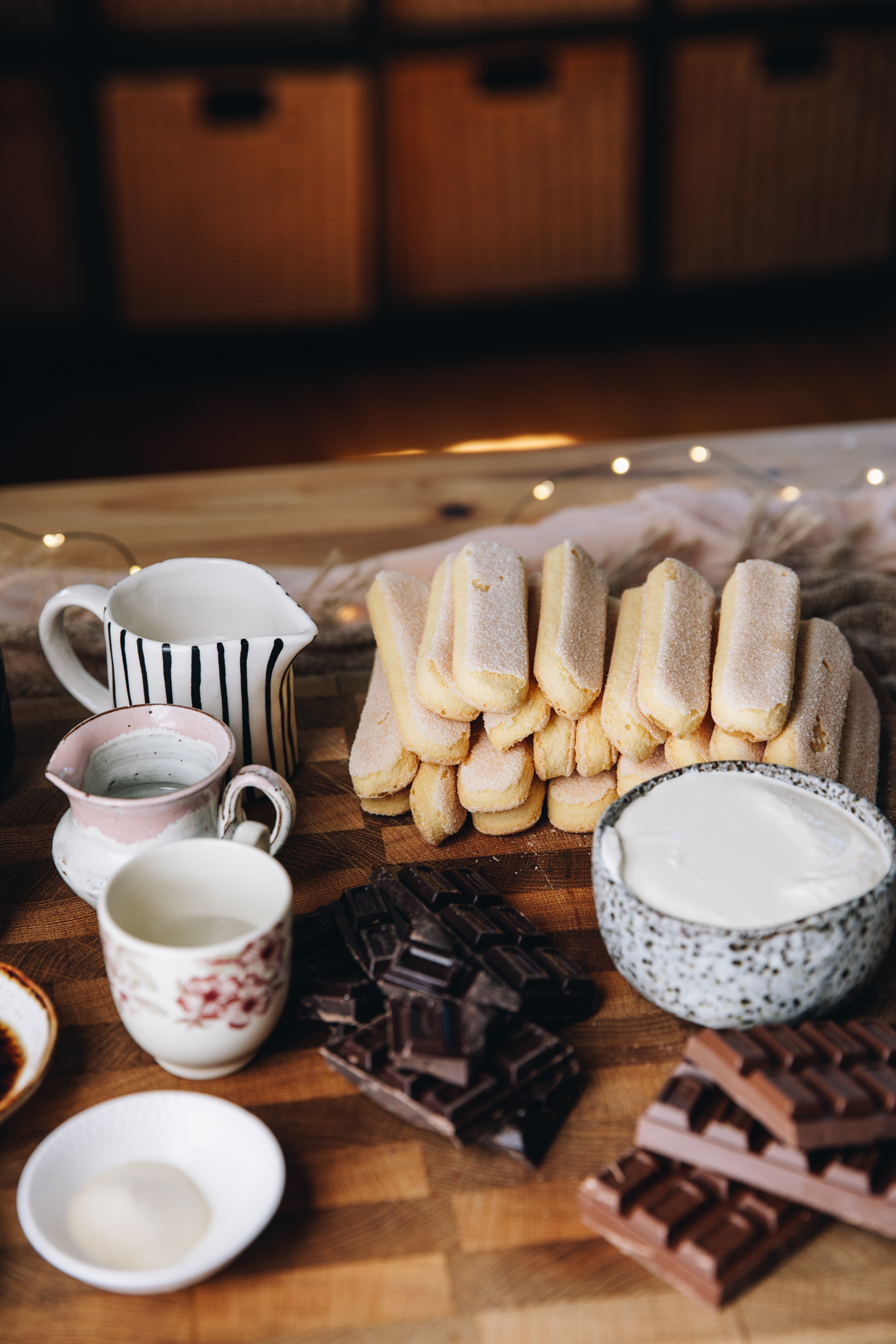 No-bake Chocolate Charlotte Cake ingredients are in different vintage bowls and are sitting on a wooden board on top of wooden table. 