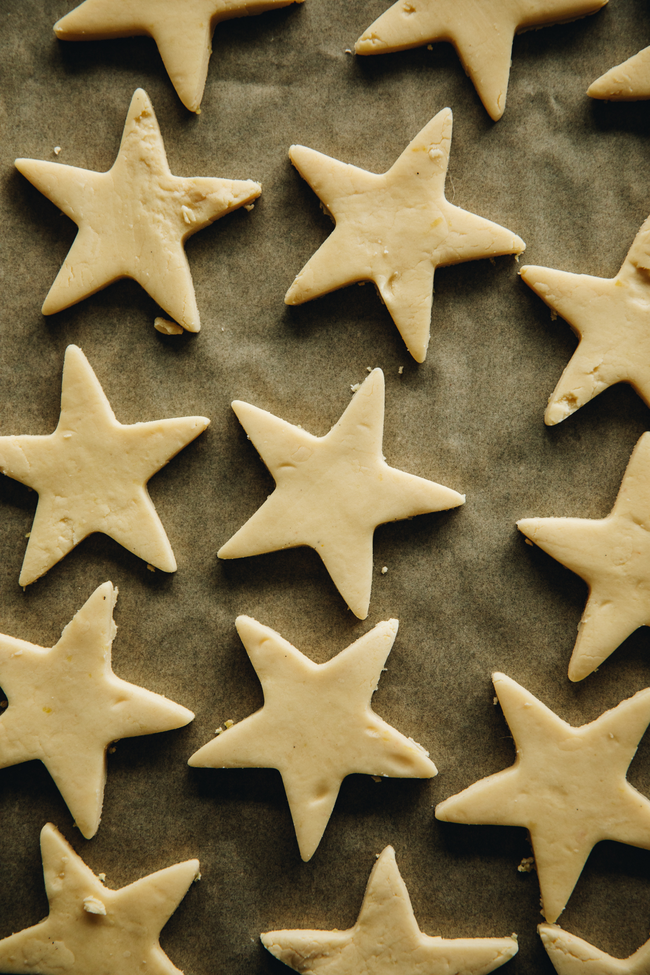 A flat lay shot reveals a tray of unbaked lemon shortbread cookies that have been cut in to stars with a cookie cutter. 