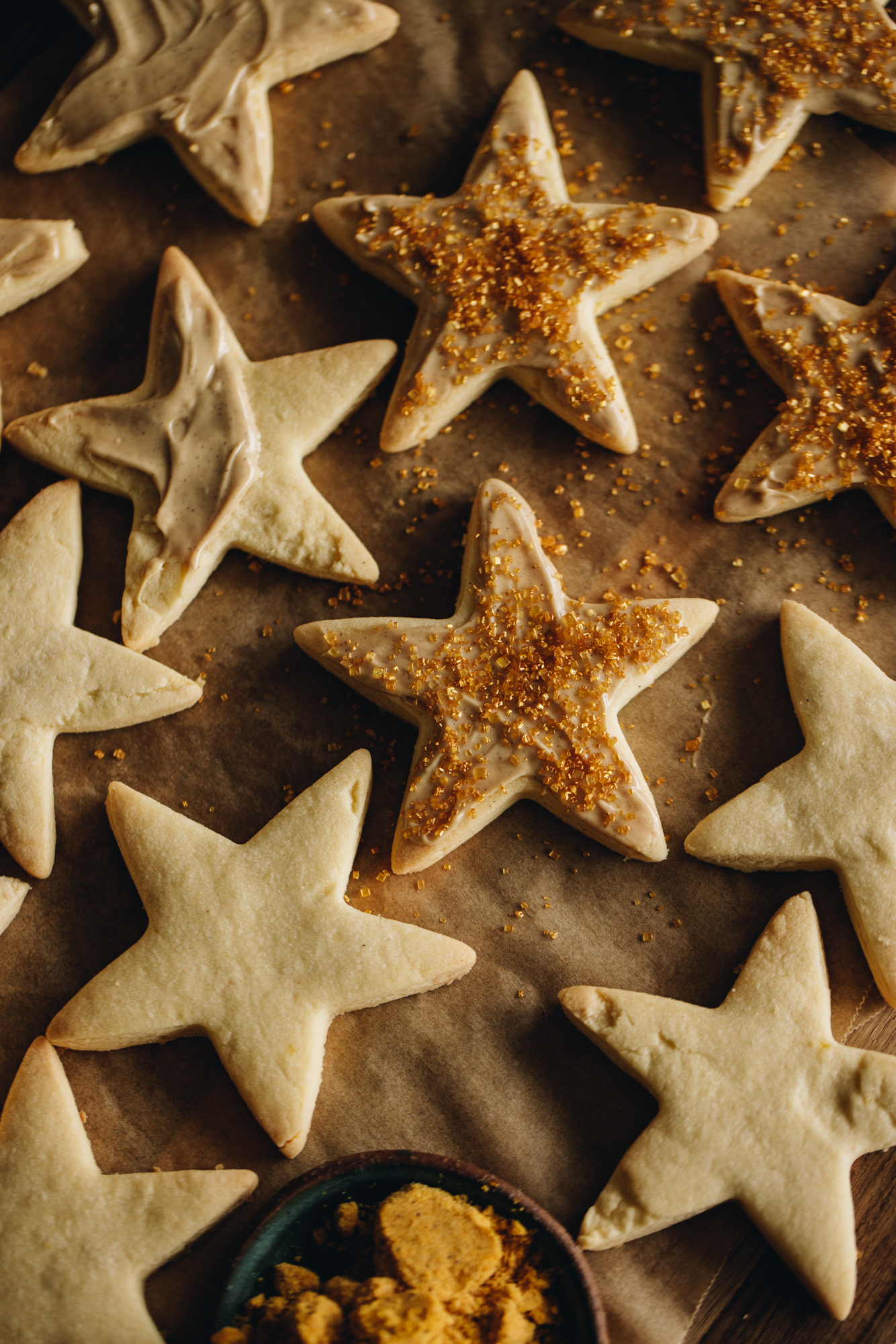 A flat lay shot reveals some of the lemon shortbread cookies. Some are plain, some have white chocolate on them and some have gold sprinkles. 