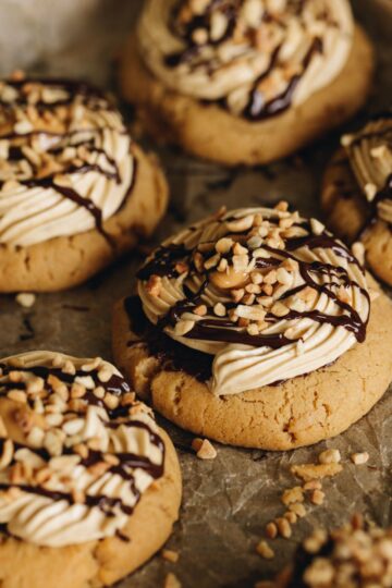 A full of tray of freshly baked and decorated ultimate peanut butter cookies on baking paper.