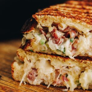 A close up of a Maple Bacon and Cheese Toastie that has been cut in half and piled on top of each other to reveal the inside.