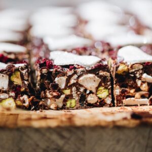 Close up of Homemade Rocky Road Recipe cut in to slices, sitting on a wooden board.