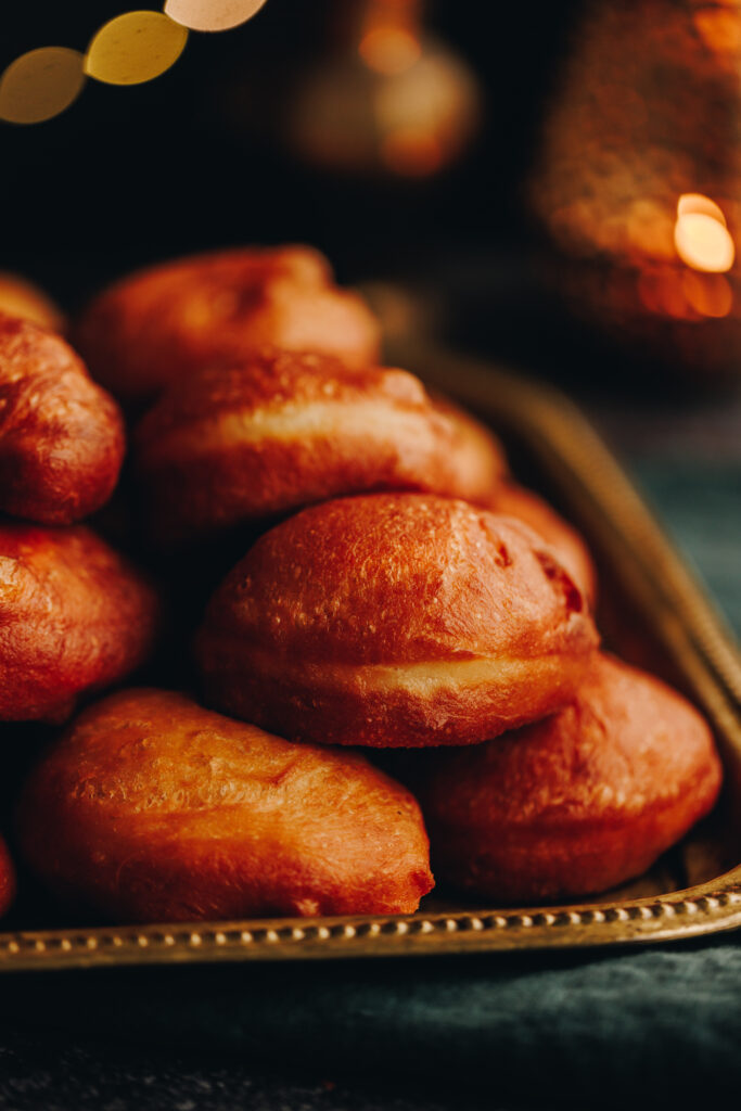 A pile of Light and Fluffy Fry Bread served on a gold tray with golden blurred lights in the background. 