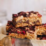 Close up of Peanut butter muesli bars piled on top of each other in a silver lunchbox.