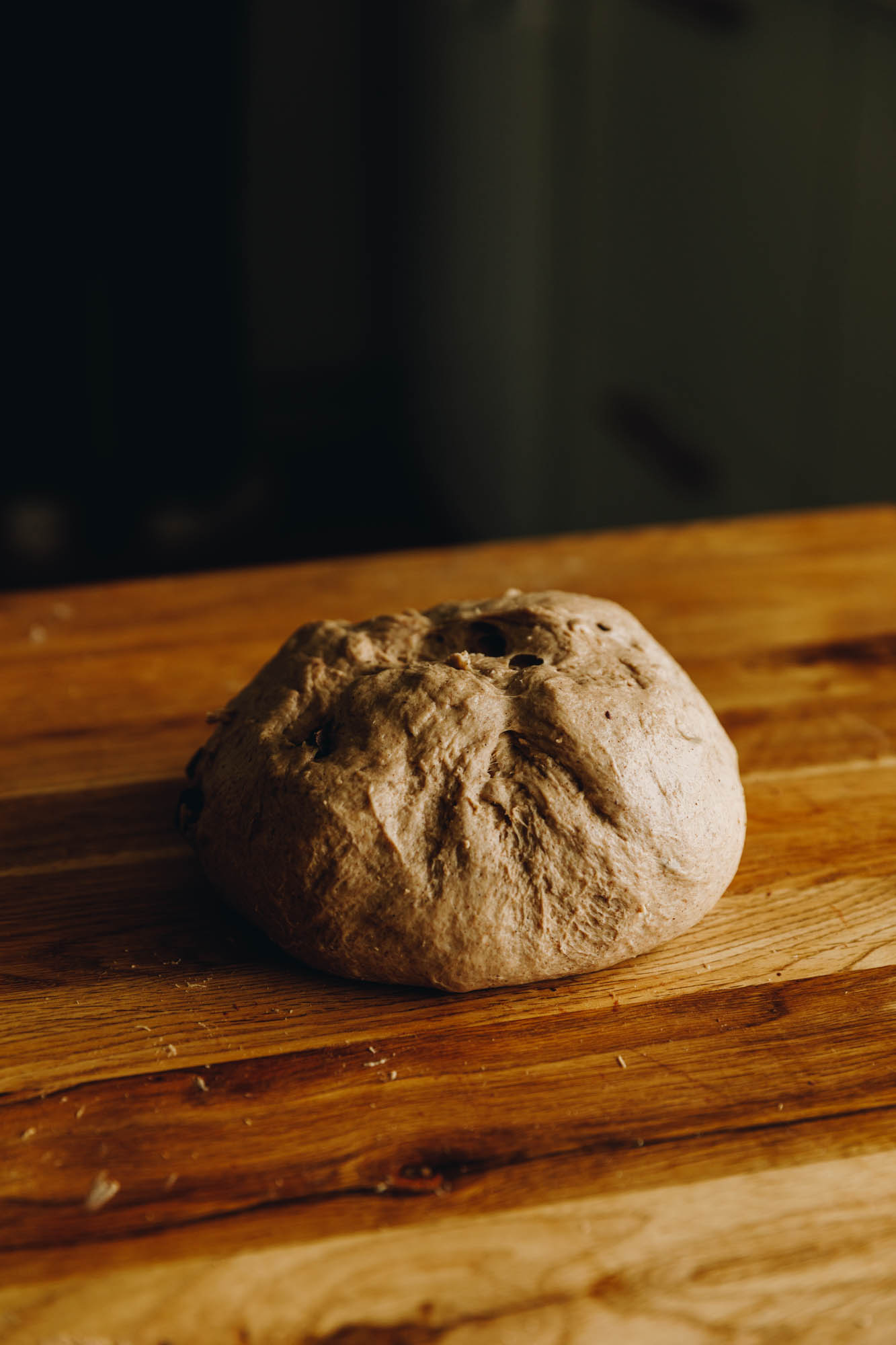 A heavily spiced dough sits on a wooden table.