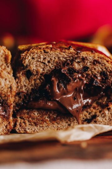 Close of Nutella Hot Cross Buns that have been sliced open and really gooey Nutella come out of the centre of the buns.