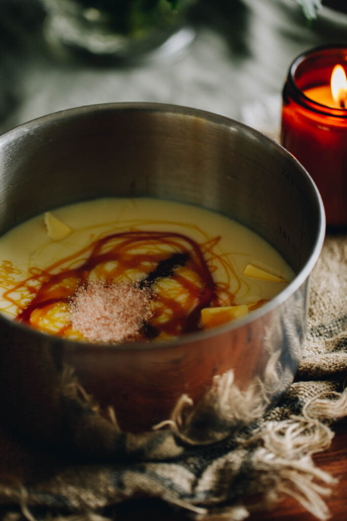 Best Oaty Caramel Slice caramel ingredients in a pot. In the pot is sweetened condensed milk, golden syrup swirls and salt. 