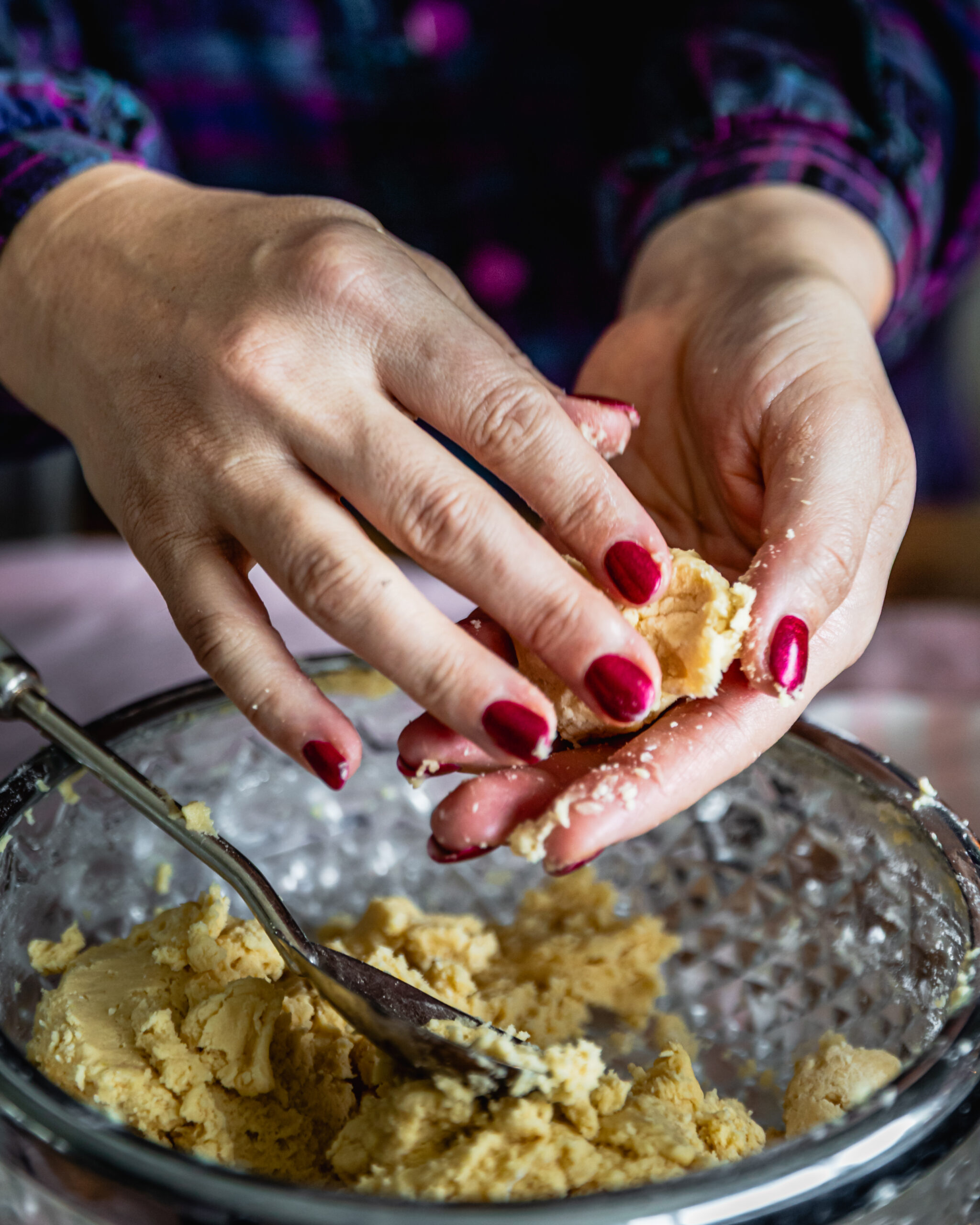 The Strawberry Jam Drop cookie dough is in a glass vintage bowl and some is in Naomi's hands showing the texture.
