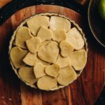 A high shot reveals the heart pastry top of the roast chicken pie, sitting on a wooden board.