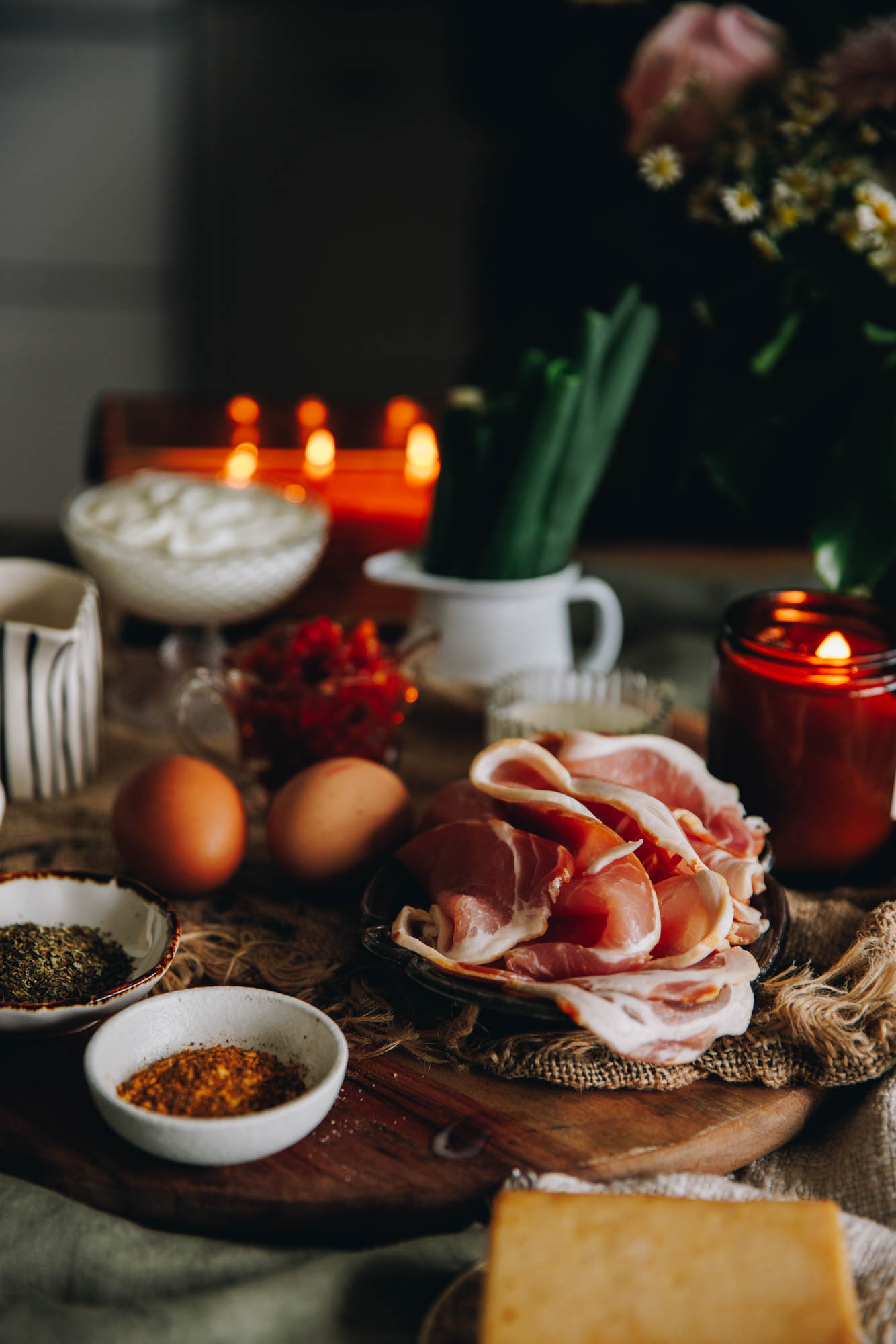 Cheesy Bacon Savoury Muffins ingredients are on a wooden board in vintage cups, spoons and bowls.