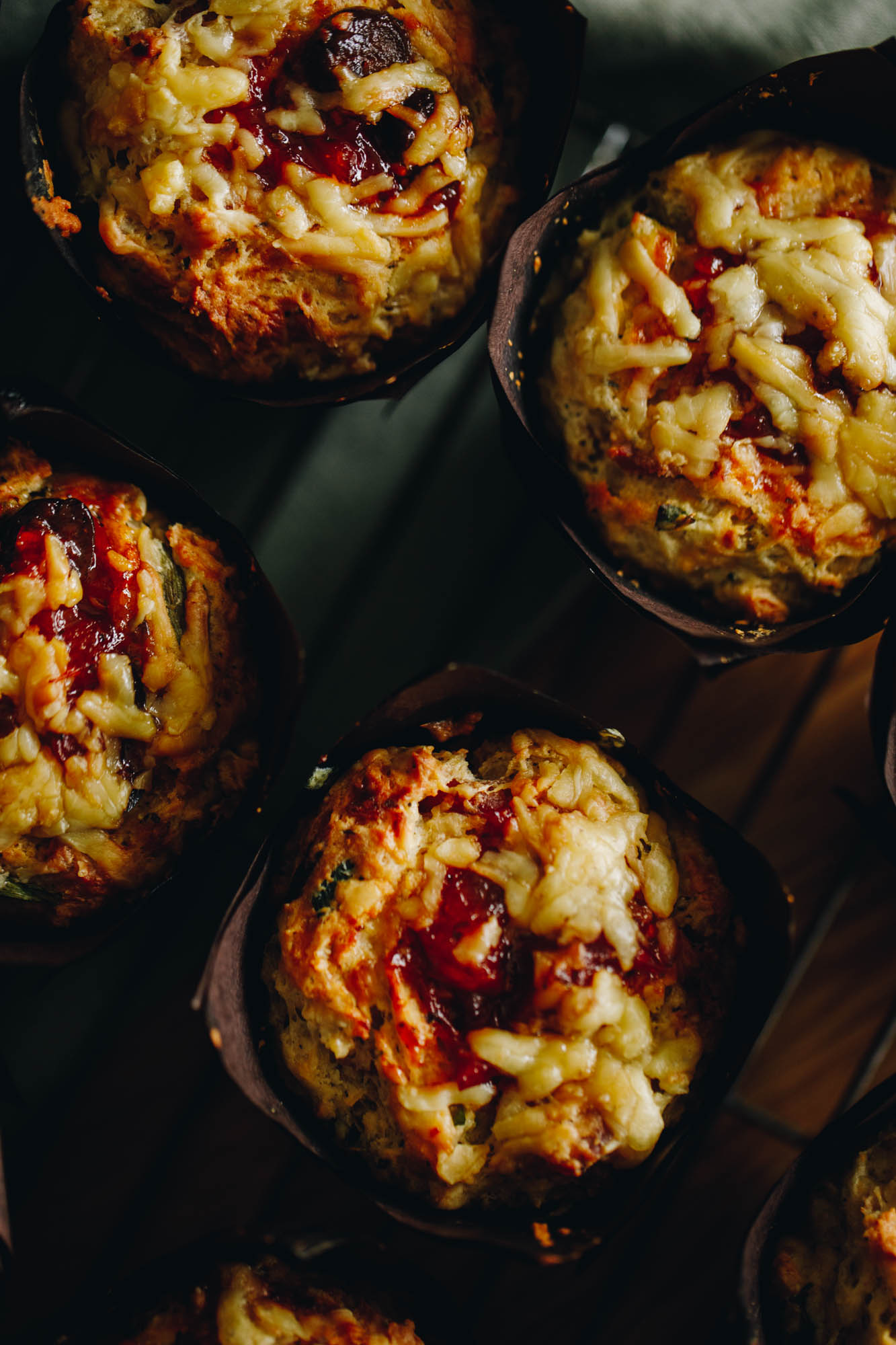 A top shot, close up shows the baked cheesy bacon savoury muffins. 