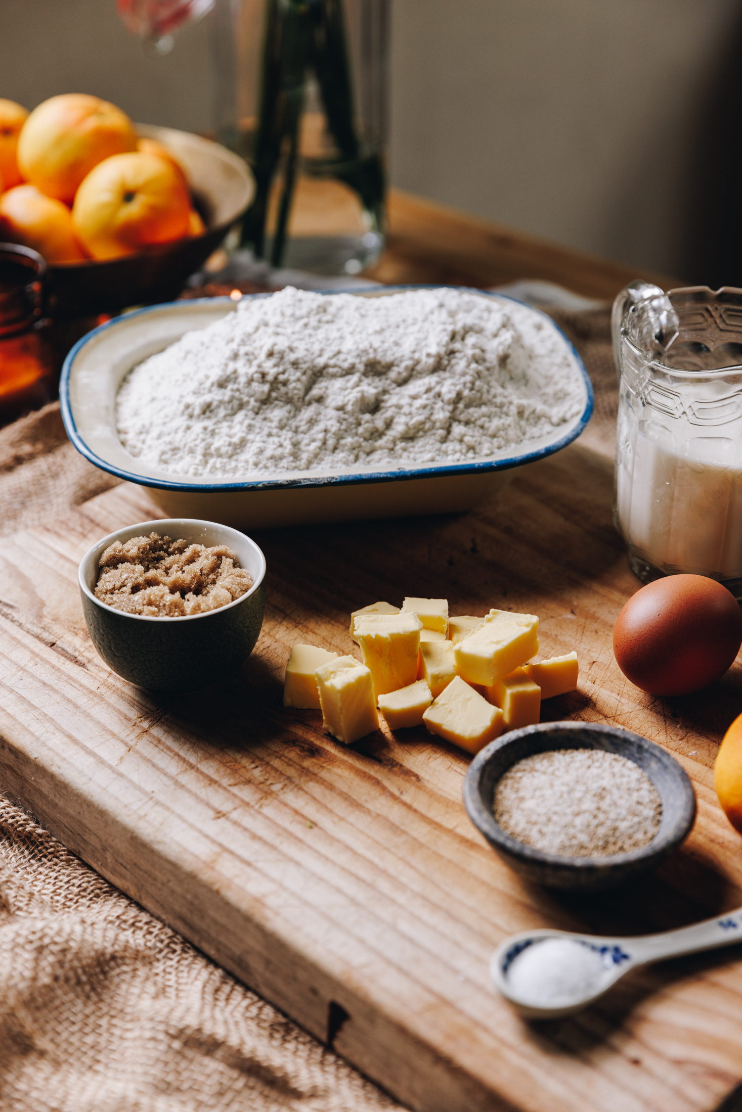 Custard and Raspberry Scrolls ingredients are on a wooden board in vintage cups, spoons and bowls. 