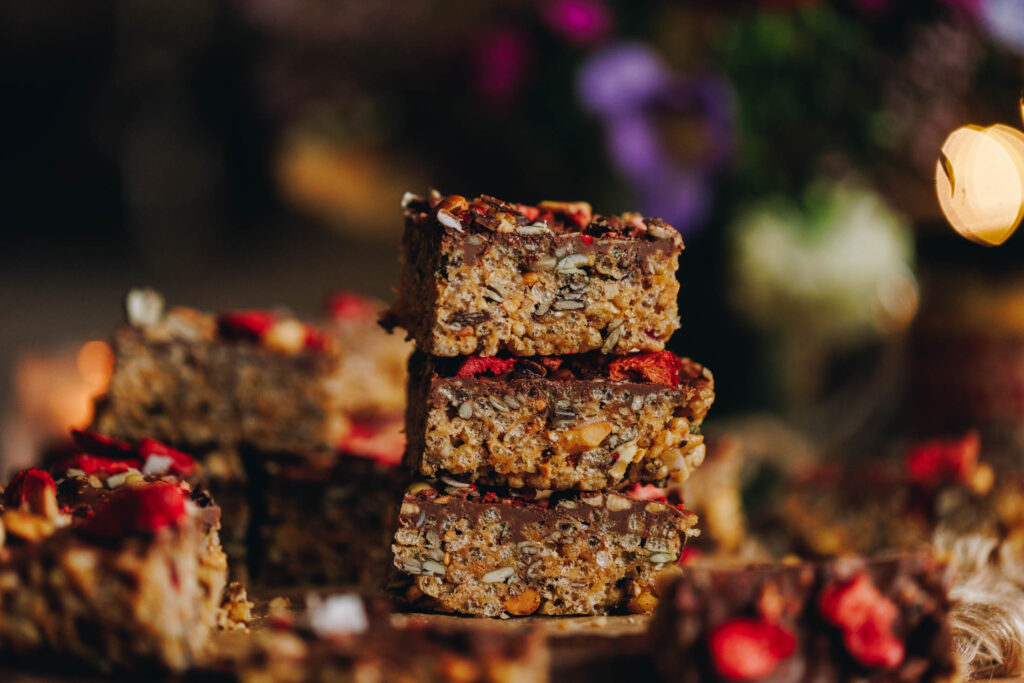 Three pieces of Peanut Butter Rice Bubble Slice are stacked on top of each other in a close shot.
