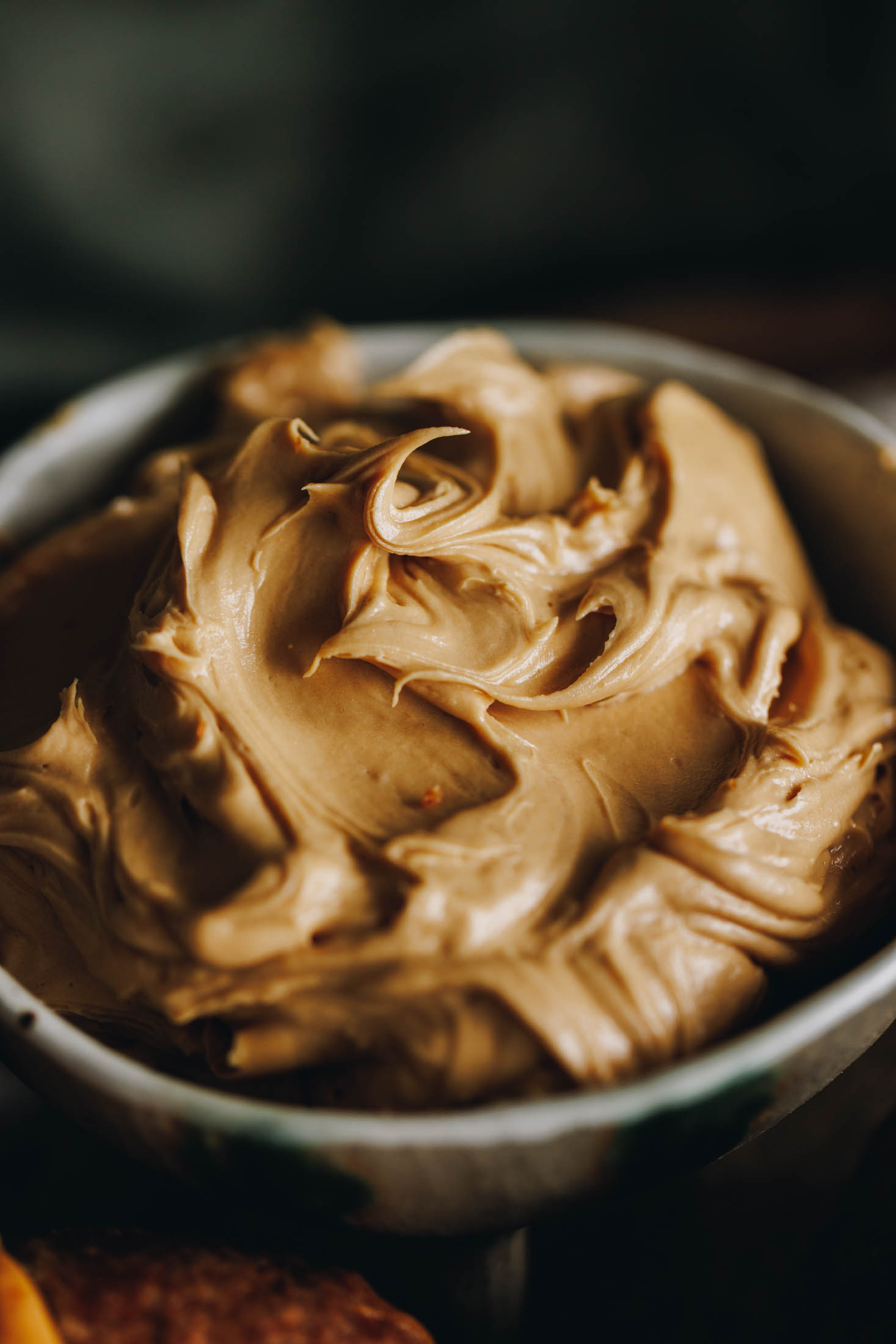 A close up shows a ceramic bowl with whipped biscuit spread butter, it is super creamy.