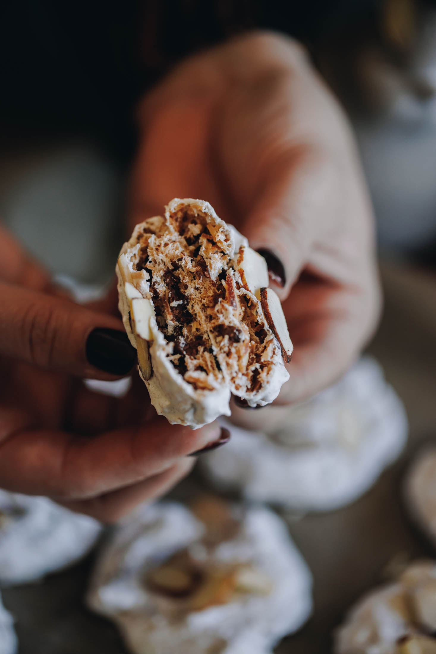 A forgotten cookie broken open to reveal a coconut, almond and chocolate centre inside a crispy meringue shell.
