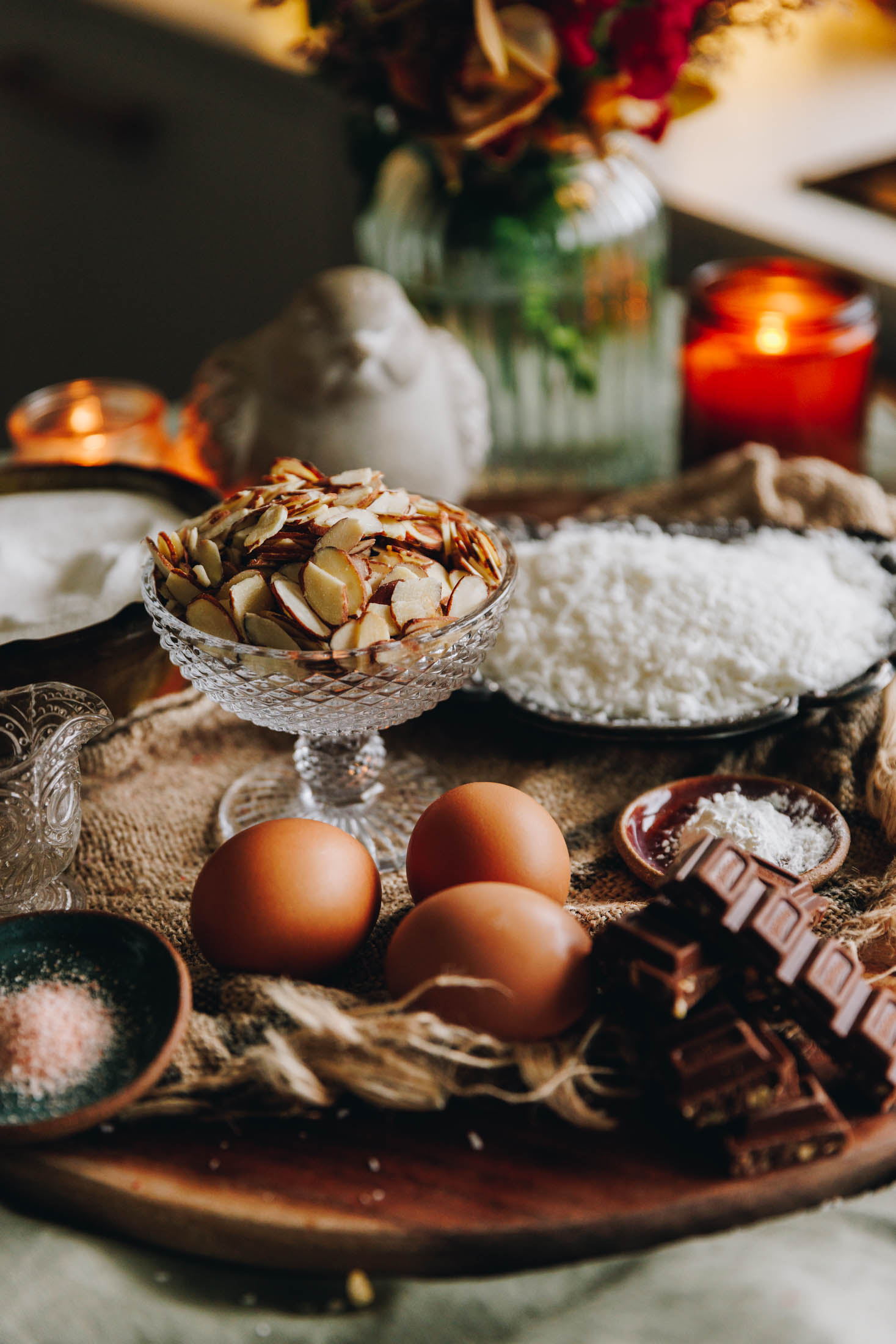 Ingredients for forgotten cookies styled on a wooden board with vintage kitchenware and flowers in the background.