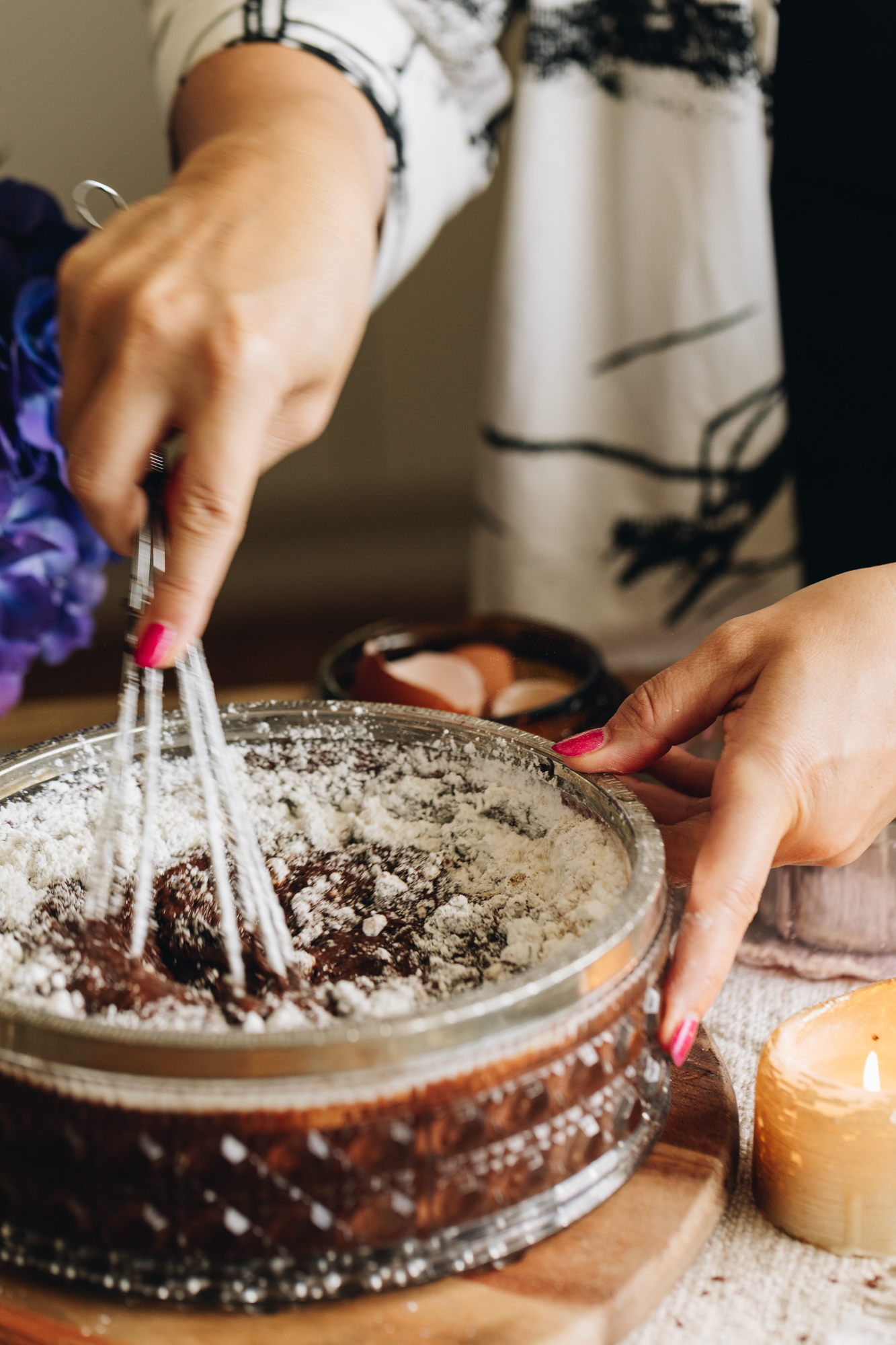 A vintage glass bowl with flour mixed into chocolate batter. 