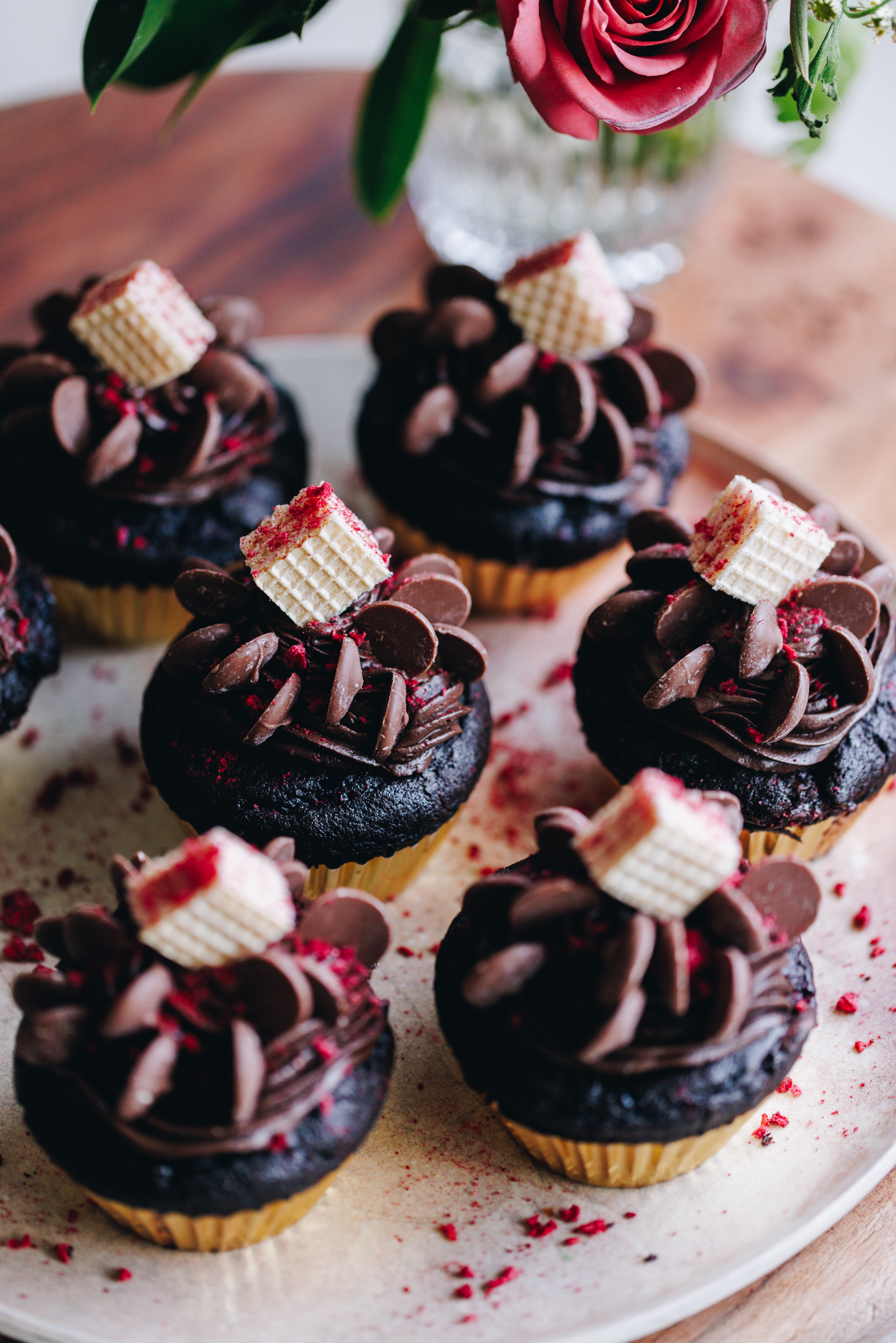 Double chocolate muffins on a pink plate with a pink rose in the background. 