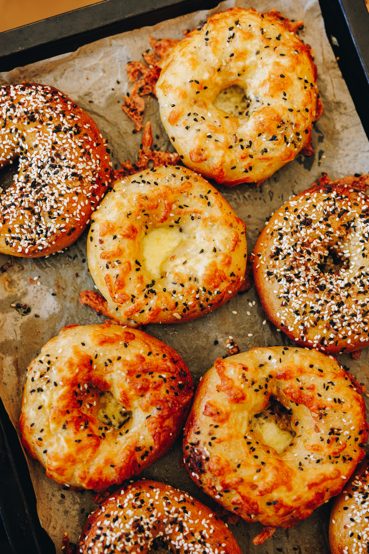 Flat lay of golden bagels with seeds and cheese on top. 